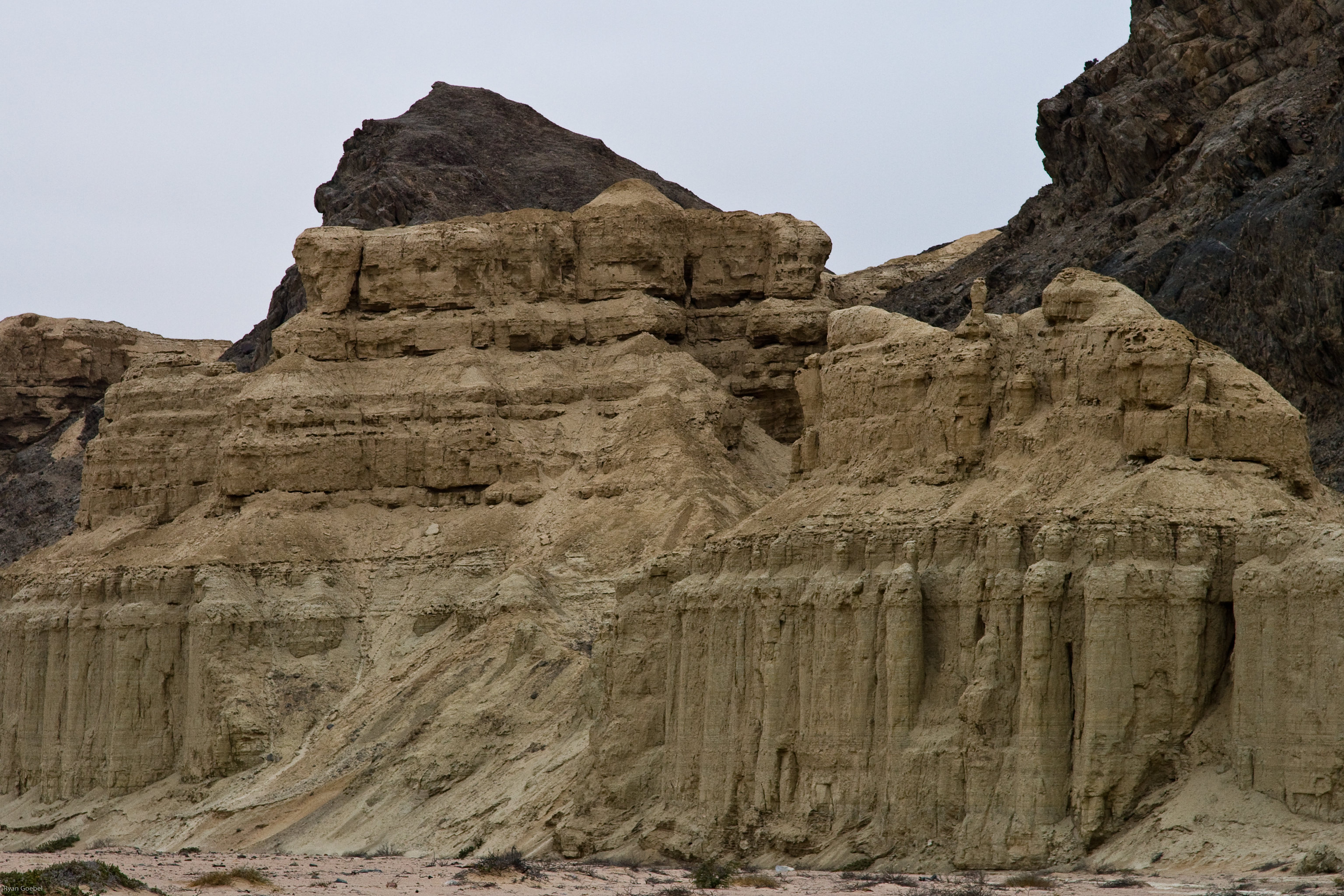  Gros plan sur le relief d'un château d'argile adossé à un massif rocheux. Vallée de l'Hoarusib, Parc National de la Côte des Squelettes, Namibie.